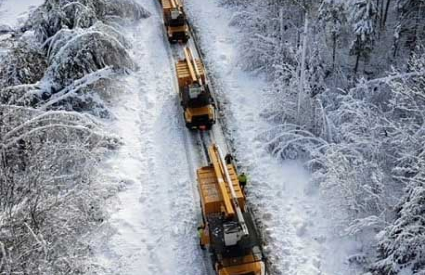 Overhead view of several NG Gilbert trucks driving through a wintery landscape.