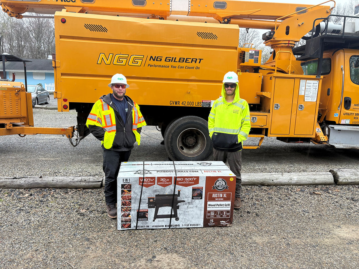 Two men standing in front of a truck with a large box.