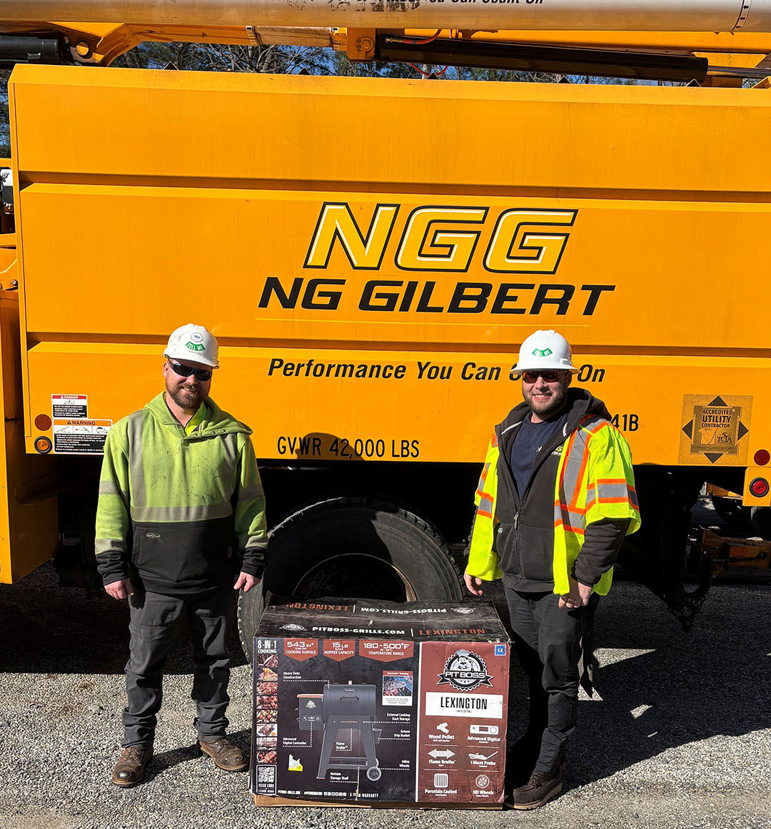 Two men standing next to a truck with a large box.