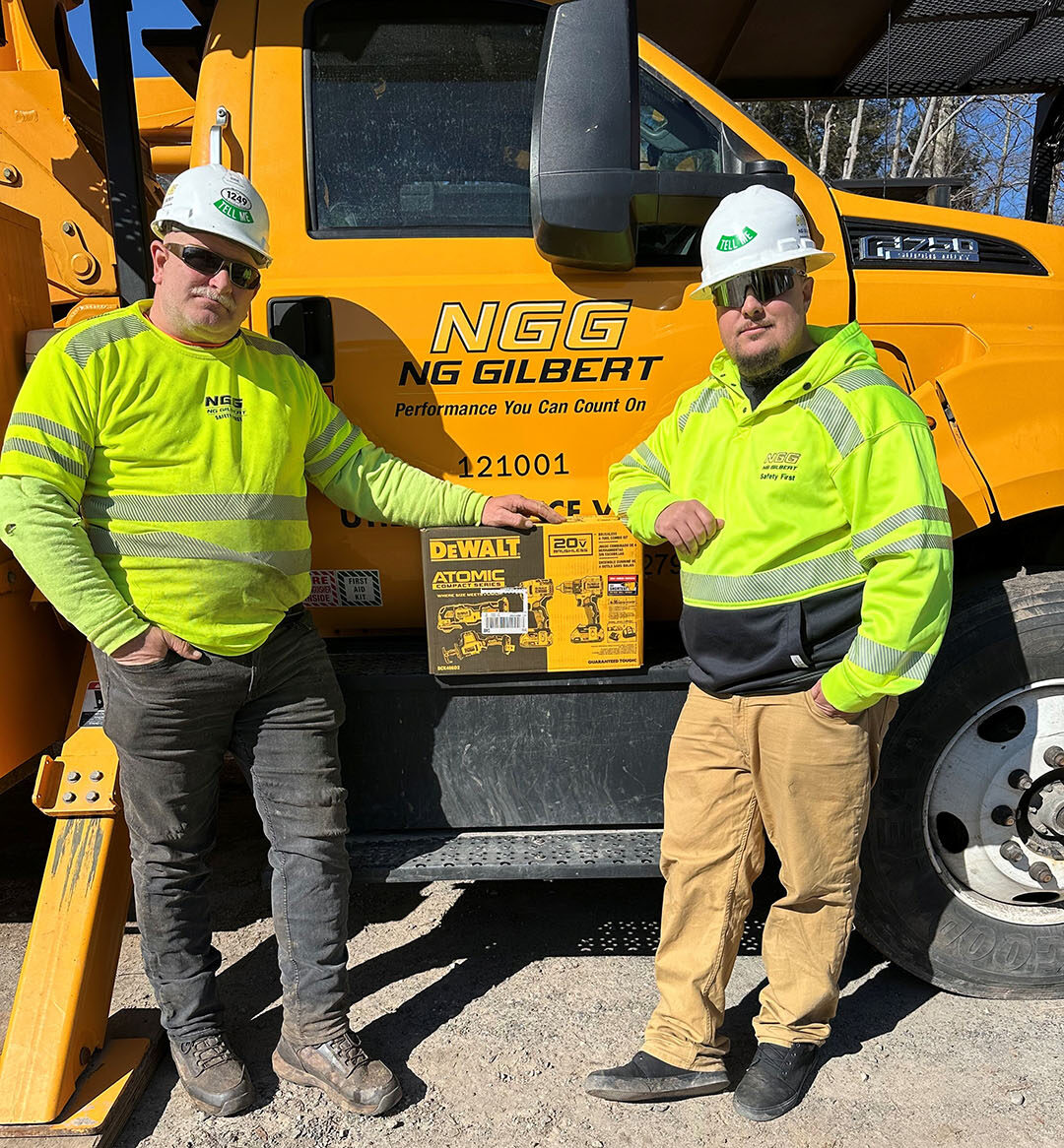 Two men standing on the side of a truck.